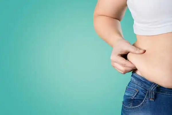Image of woman pinching her love handles to show weight gain Margate